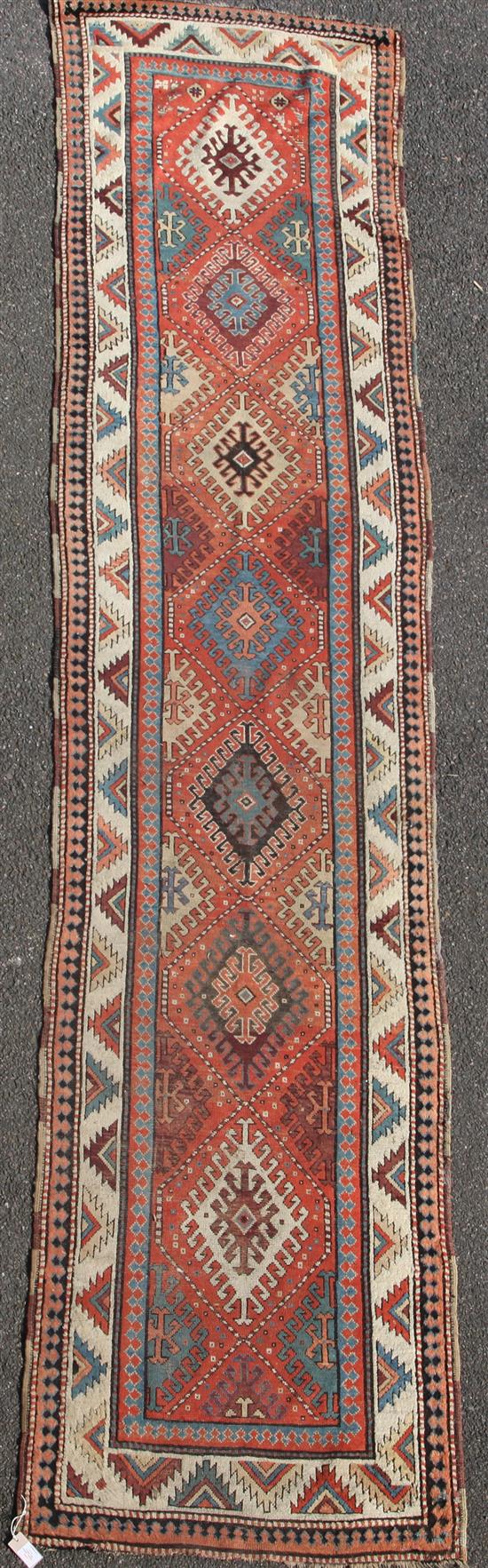 A Kazak red ground runner c.1850, 13ft by 3ft.